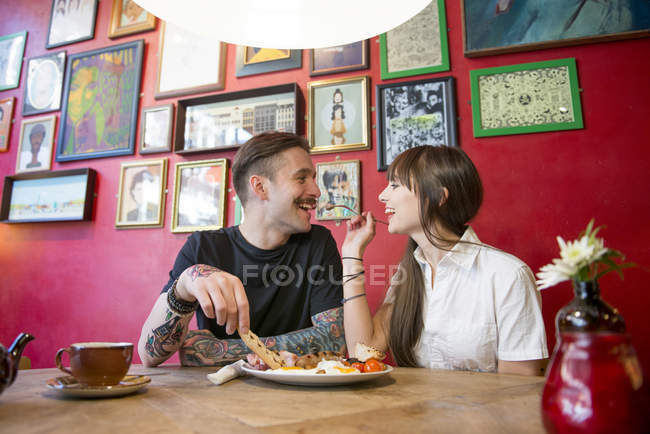 Пара наслаждается едой в кафе — стоковое фото