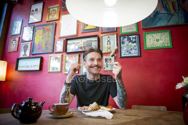 Hombre comiendo en en la cafetería - foto de stock