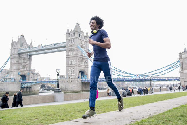 Mann joggt an Turmbrücke vorbei — Stockfoto