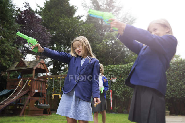 Niñas jugando con pistolas de agua - foto de stock