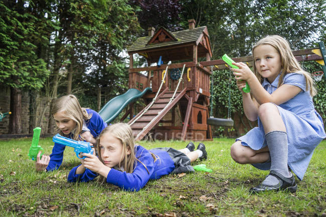 Girls playing with water pistols — Stock Photo