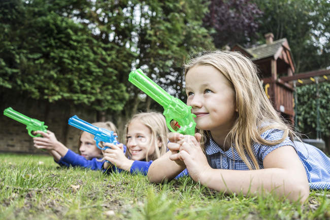 Girls playing with water pistols — Stock Photo