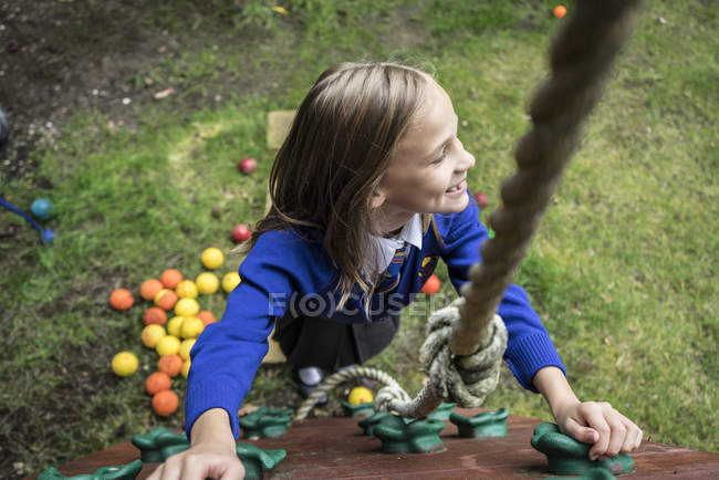 Girl climbing on playground apparatus — Stock Photo