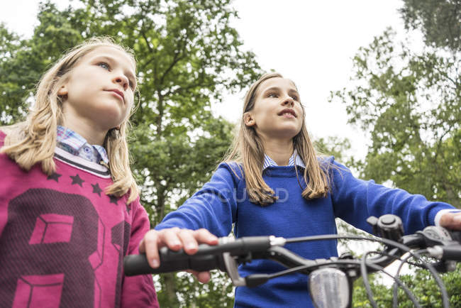 Girls playing on bicycle outside — Stock Photo