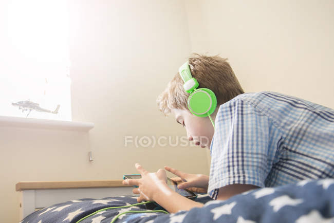Хлопчик слухає музику в навушниках — стокове фото