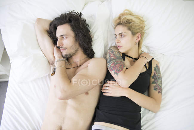 Пара лежить на ліжку після суперечки — стокове фото