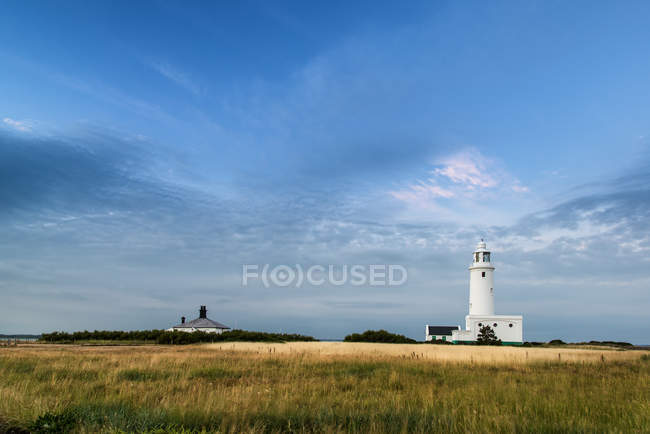 Summer sky with lighthouse in distance — Stock Photo