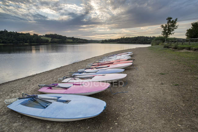 Lake in landscape with leisure boats on shore — Stock Photo