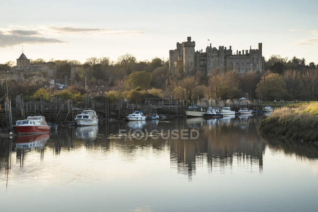Средневековый замок с видом на реку на закате — стоковое фото