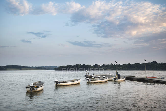 Coucher de soleil des bateaux de loisirs amarrés sur la jetée dans le lac — Photo de stock