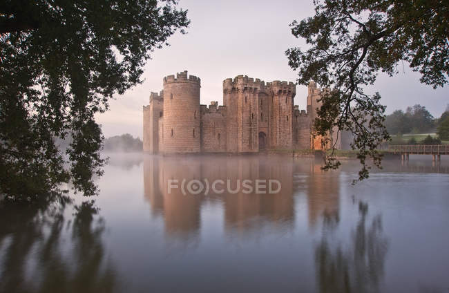 Beautiful medieval castle and moat at sunrise — Stock Photo