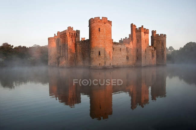 Beau château médiéval et douves au lever du soleil — Photo de stock