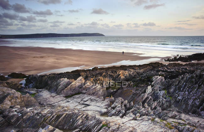 Coppia sagomata passeggiando lungo la spiaggia — Foto stock