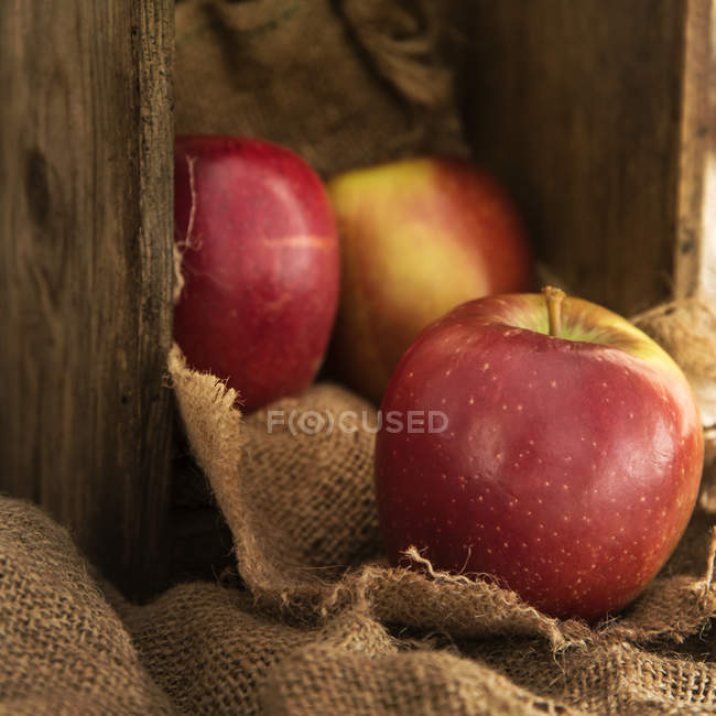 Red apples in old wooden box — Stock Photo