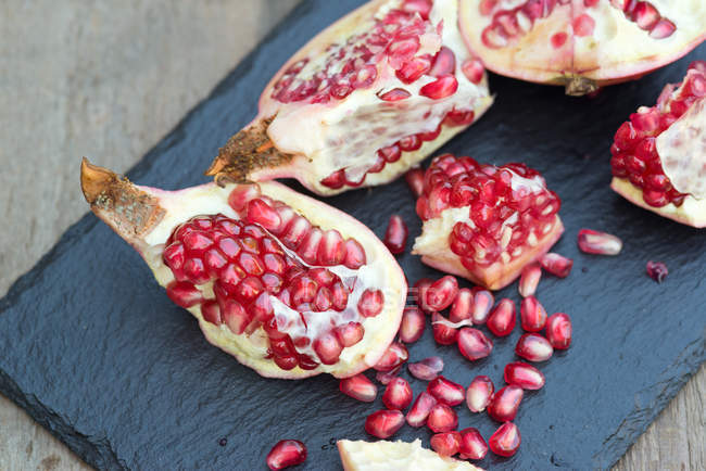 Fresh pomegranate sliced and ripped — Stock Photo