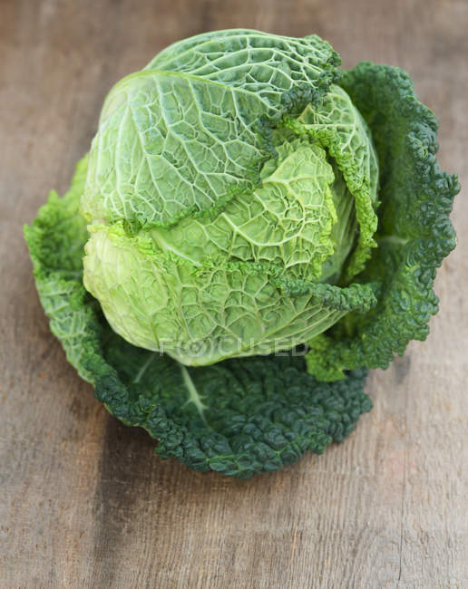 Savoy Cabbage on wooden background — Stock Photo
