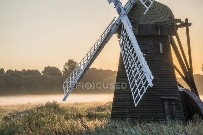 Старая ветряная мельница в туманной английской деревне — стоковое фото