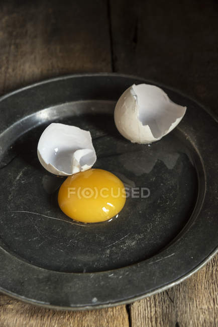 Œuf de canard fissuré sur assiette — Photo de stock