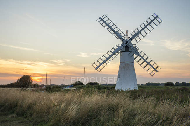 Paysage de moulin à vent et rivière au lever du soleil — Photo de stock