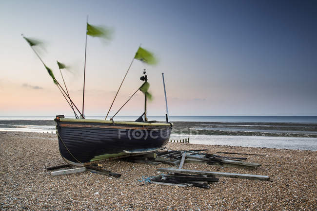 Небольшие рыбацкие лодки на пляже на восходе солнца — стоковое фото