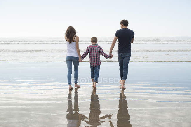 Пара і син ходити в сонця на пляжі — стокове фото