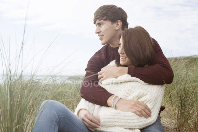 Casal abraçando em dunas na praia — Fotografia de Stock