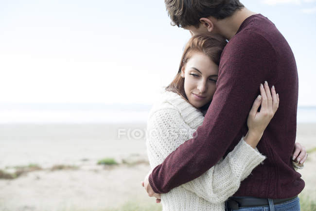 Pareja abrazándose en la playa - foto de stock