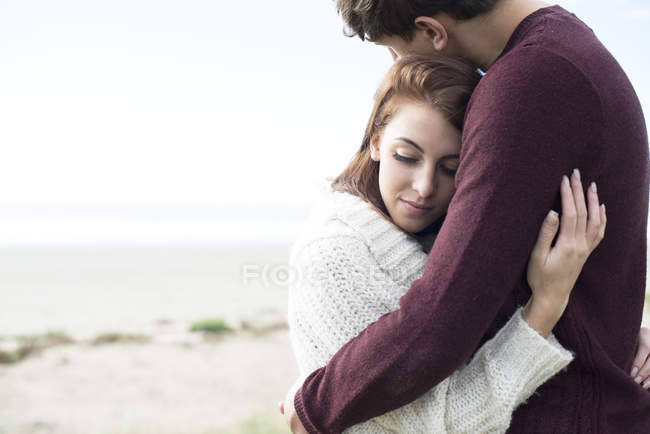 Casal abraçando na praia — Fotografia de Stock