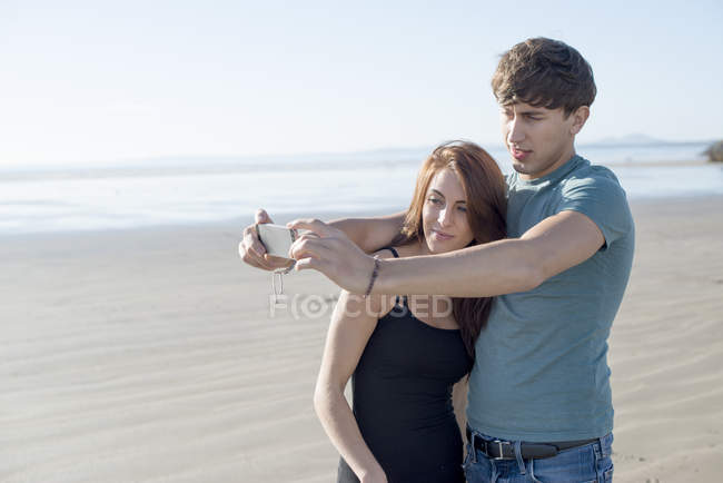 Coppia scattare selfie sulla spiaggia — Foto stock