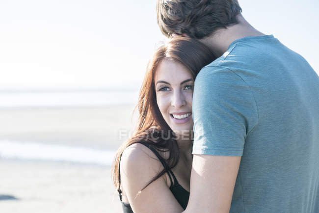 Pareja abrazándose en la playa - foto de stock