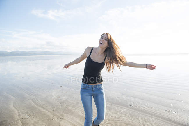 Mulher desfrutando da luz do sol na praia — Fotografia de Stock