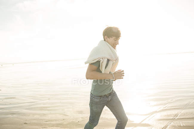 Чоловік насолоджується сонячним світлом на пляжі — стокове фото