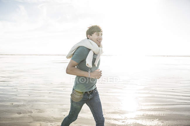 Hombre disfrutando del sol en la playa - foto de stock