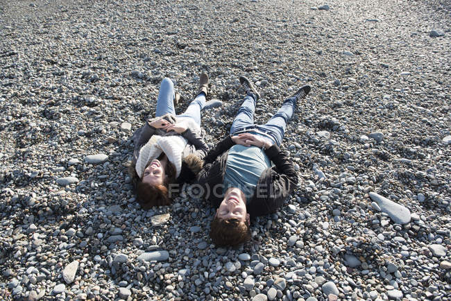 Couple couché ensemble sur la plage — Photo de stock