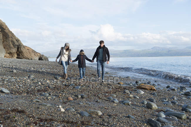 Couple and son walking in sunshine on beach — Stock Photo