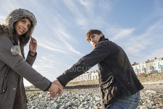 Couple marchant tout en tenant la main sur la plage — Photo de stock