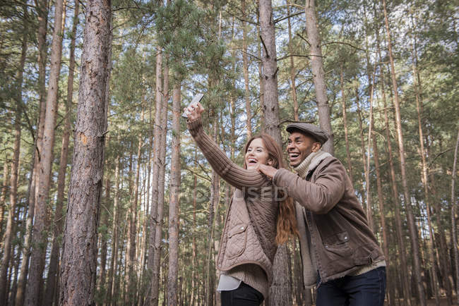 Pareja tomando selfie en bosque - foto de stock