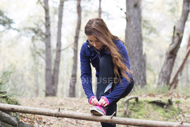 Frau bereitet sich auf Joggen durch Wald vor — Stockfoto