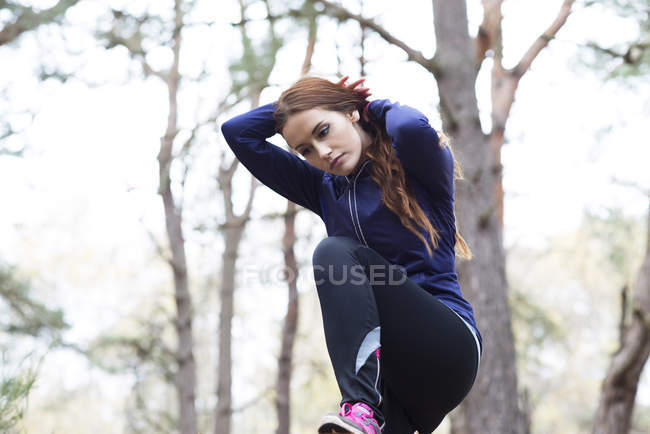 Femme se préparant à faire du jogging dans la forêt — Photo de stock