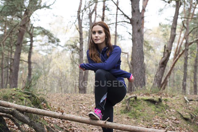 Donna che si prepara ad andare a correre attraverso la foresta — Foto stock