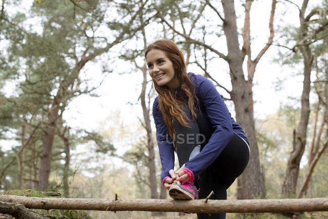 Woman preparing to go for jog through forest — Stock Photo