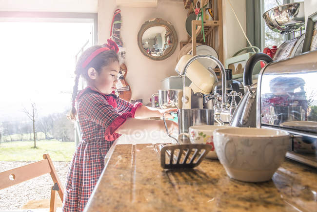 Mädchen spült Geschirr in der Spüle — Stockfoto
