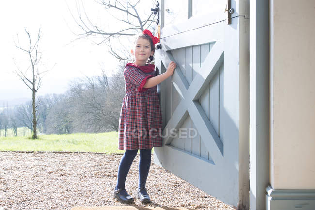 Girl standing at back door — Stock Photo