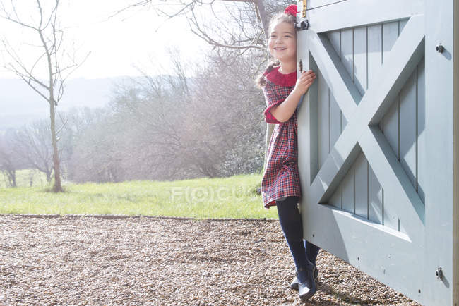 Girl standing at back door — Stock Photo