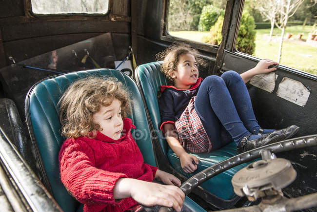 Crianças brincando no carro vintage — Fotografia de Stock
