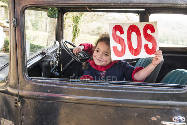 Girl holding SOS sign up — Stock Photo