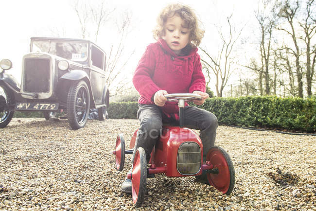 Boy sitting on toy tractor — Stock Photo
