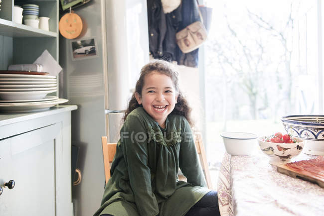 Girl sitting at kitchen table waiting for lunch — Stock Photo