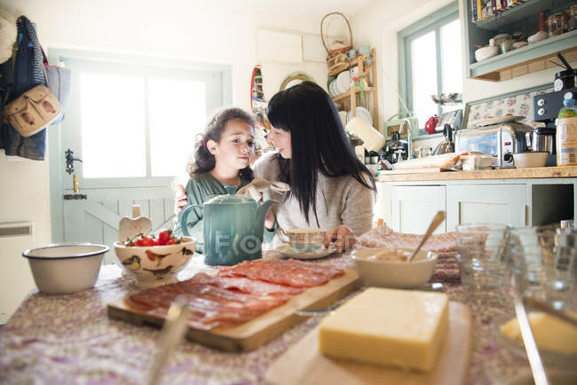 Девушка утешается матерью за обеденным столом — стоковое фото
