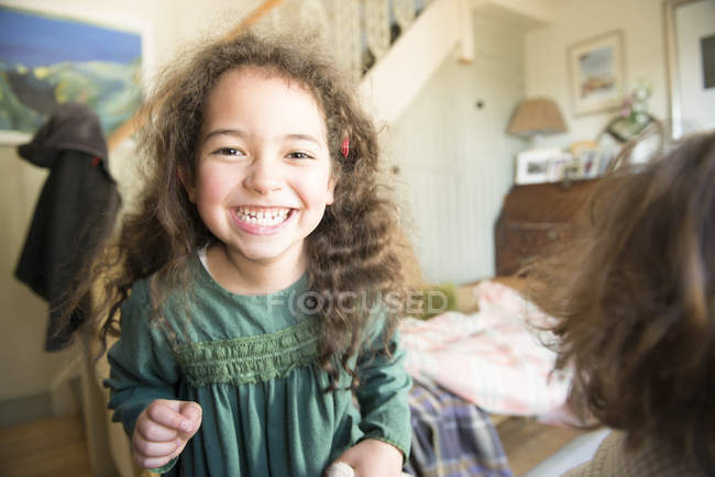 Girl in green dress stands in room — Stock Photo